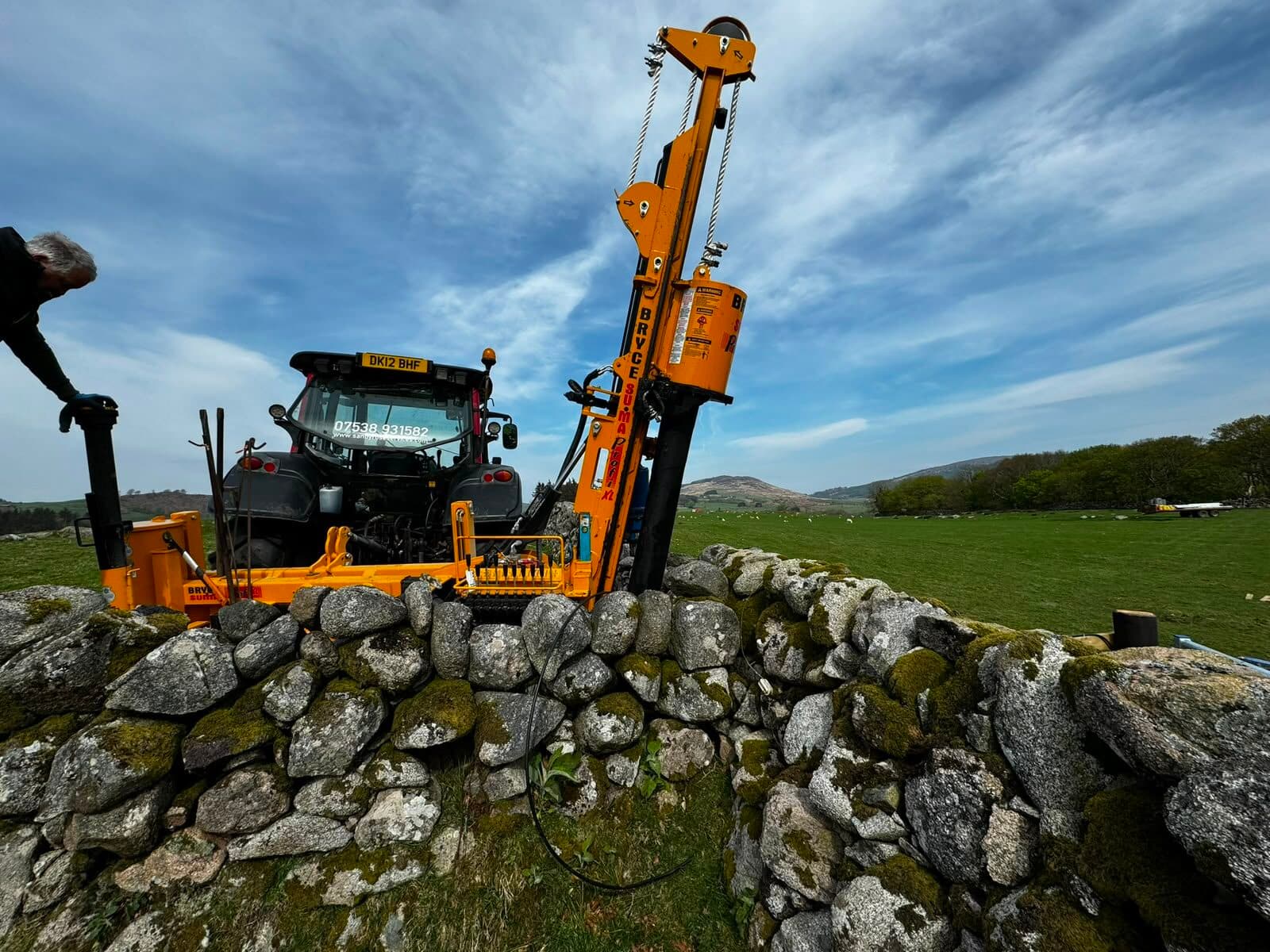 Tractor-mounted post-driving rig at work on a hill farm