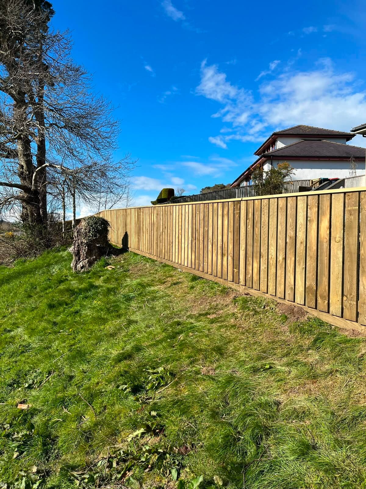 Post-and-rail fencing along a commercial yard boundary