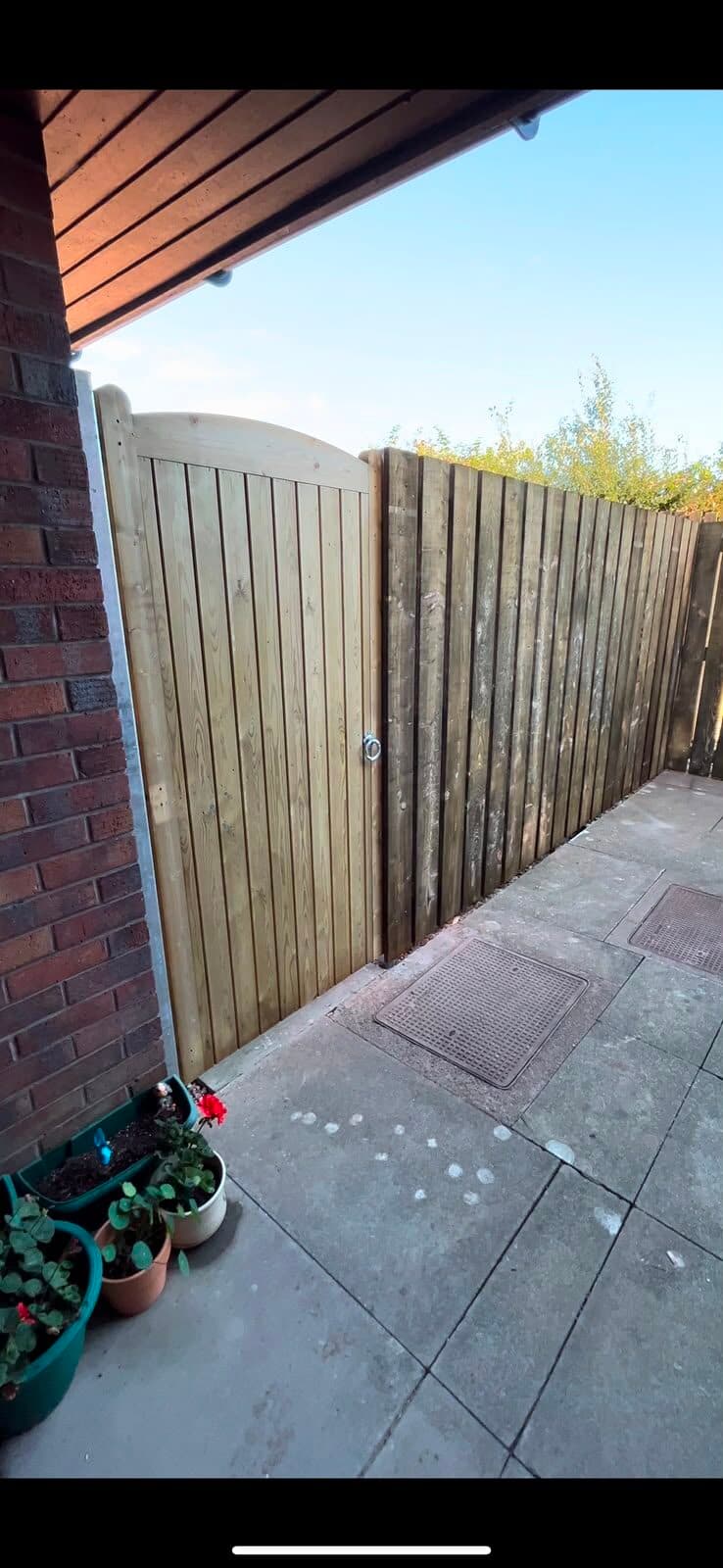 Timber gate and close-board fencing along a garden side passage