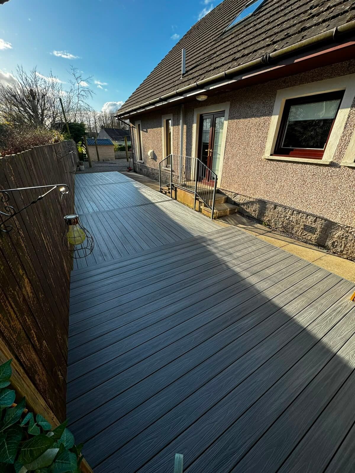 Grey composite decking built along the side of a house