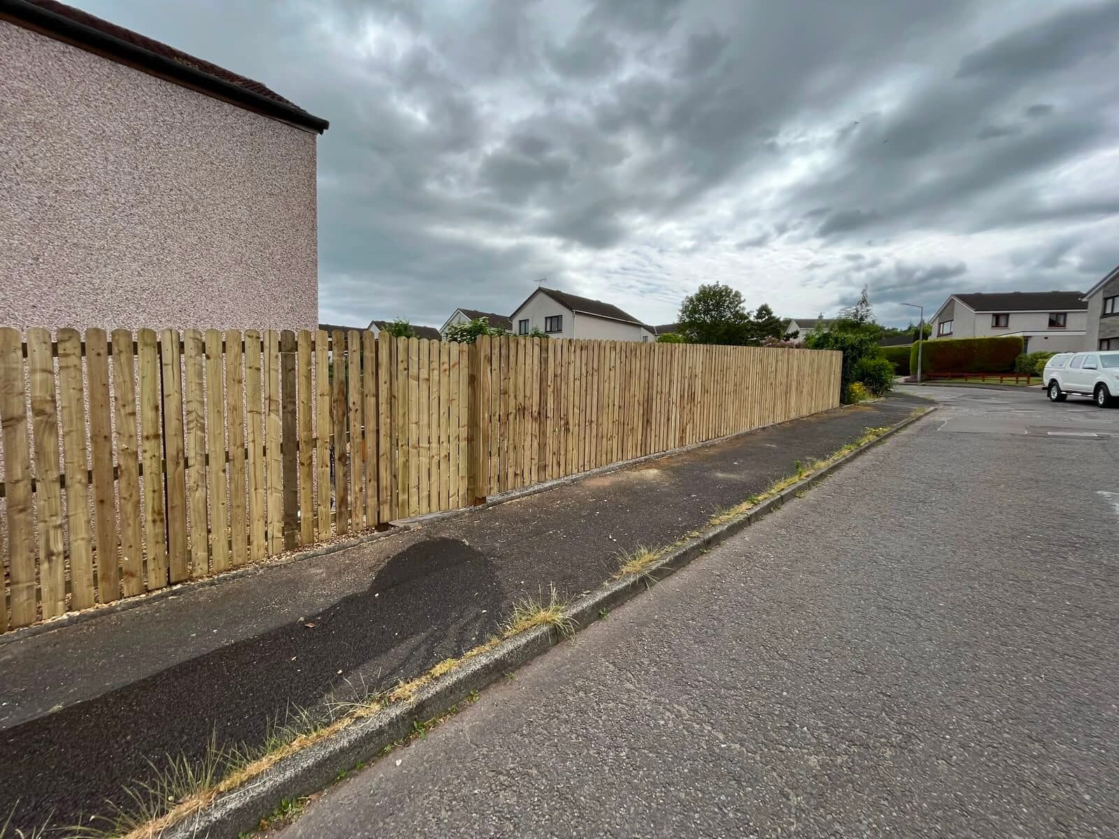 Close-board fencing alongside a block-paved driveway