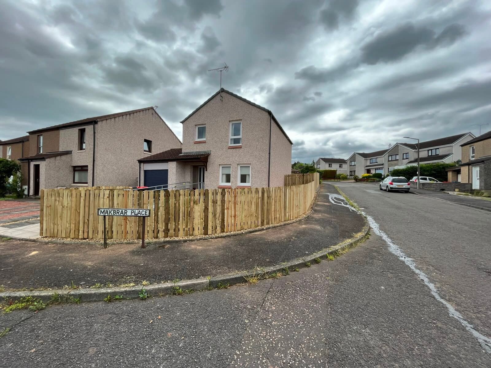 Solid panel fencing enclosing a residential driveway