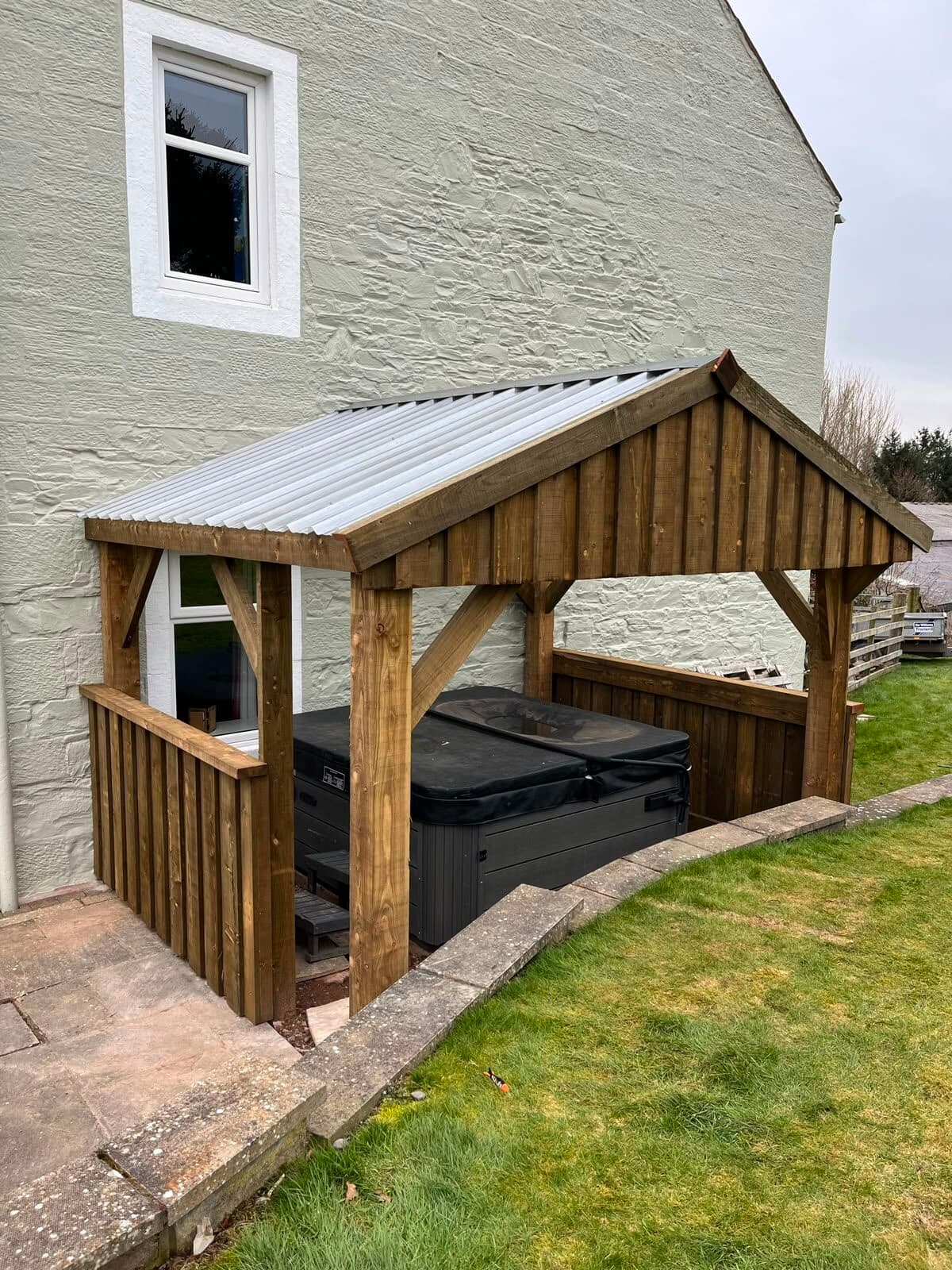 Timber-framed garden shelter with a corrugated roof, built over a hot tub