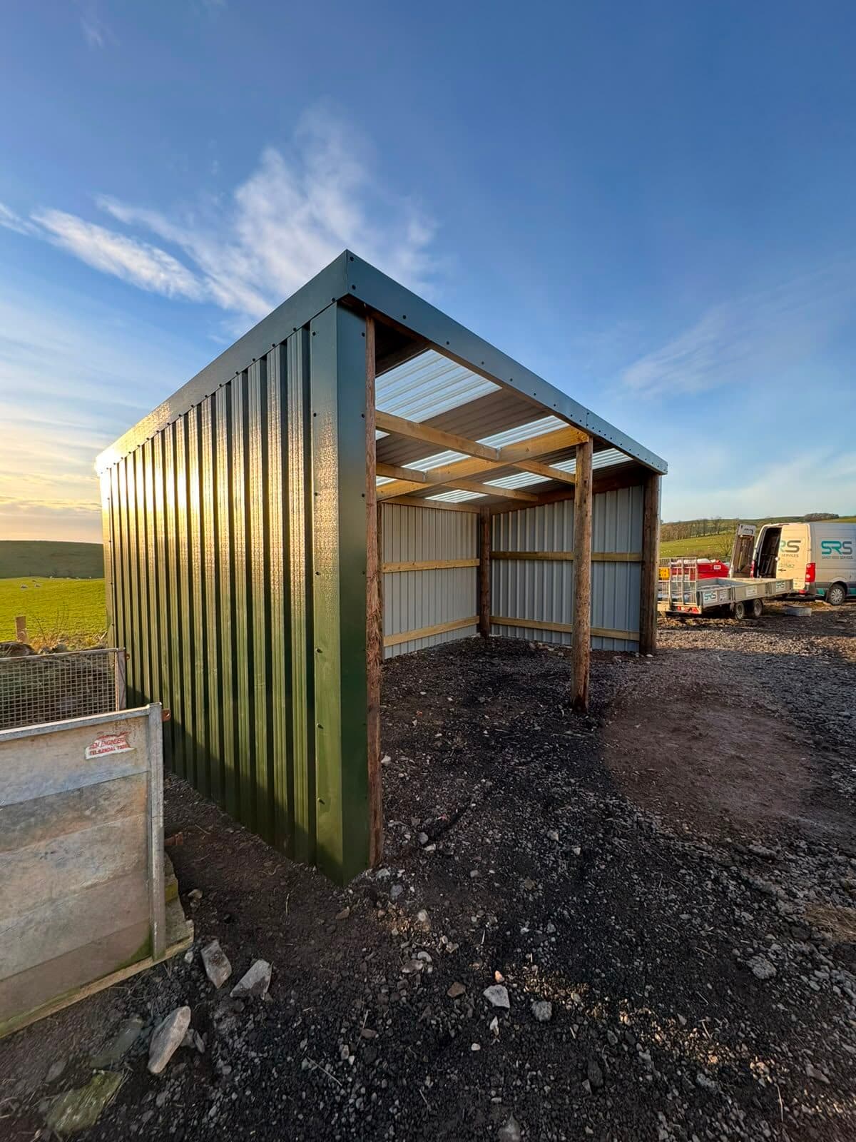 Timber-framed field shelter with a corrugated roof, built for livestock and equipment storage